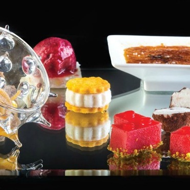 La grandezza del piatto 'Piccola pasticceria' risiede nel fatto che è realizzato solo con le verdure: creme brulè di peperone giallo, terrina di finocchio e cocco con gelato di lamponi, ringo di cavolfiori, tartufino di cipolla, spaghetto di patate con frutto della passione, pomodoro con liquirizia e pistacchi,
sassolino di melanzane e olive nere - Piatti: Piccola pasticceria - Serva -